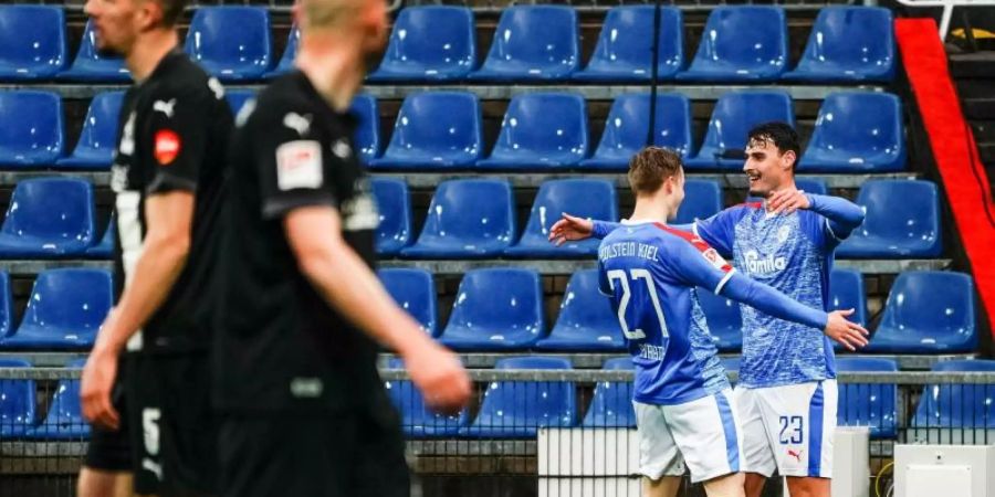 Finn Porath (l) und Janni Serra von Holstein Kiel feiern den Treffer zum 2:0 gegen den SV Sandhausen. Foto: Axel Heimken/dpa