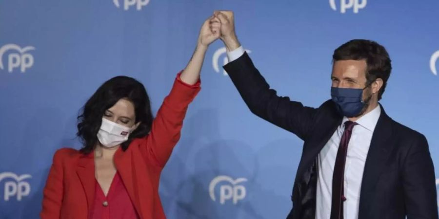 Isabel Diaz Ayuso (l) und Pablo Casado von der konservativen Volkspartei feiern ihren Wahlsieg. Foto: Bernat Armangue/AP/dpa