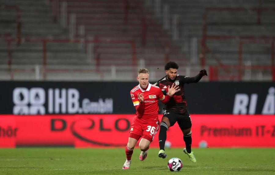 Serge Gnabry (r.) von Bayern München versucht Unions Cedric Teuchert (l.) vom Ball zu trennen.