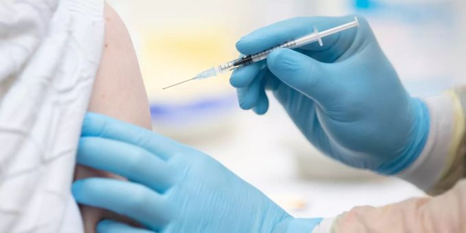 Eine Person wird im Impfzentrum in den Emslandhallen in Lingen, Deutschland, von einem Notfallsanitäter des DRK (Deutsches Rotes Kreuz) mit dem Wirkstoff von Biontech/Pfizer gegen das Coronavirus geimpft. Coronavirus Biontech