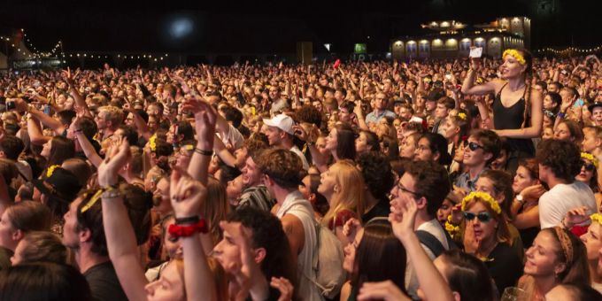 Menschen stehen Schulter an Schulter vor einer Bühne am Openair Zürich. openair coronavirus