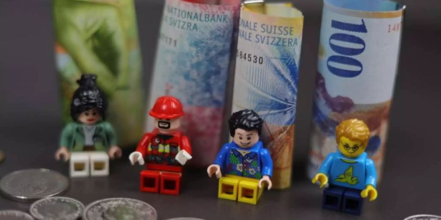 Vier Legomännchen vor Geldnötchen.