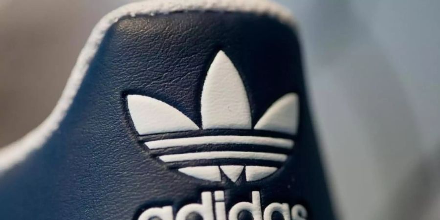 Adidas-Logo auf einem Sportschuh. Foto: picture alliance / Daniel Karmann/dpa