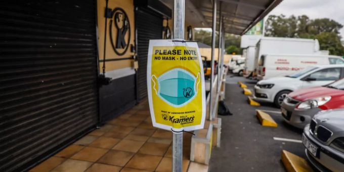 Das Schild zur Erinnerung an die Maskenpflicht hängt vor einem Spirituosenladen in der Agglomeration von Johannesburg am 29. Dezember 2020. Tags zuvor hatte Präsident Cyril Ramaphosa unter anderem Alkoholverkäufe gestoppt und die Maskenpflicht verhängt, nachdem die Grenze von einer Million Corona-Fällen überschritten worden war. Südafrika Coronavirus Lockdown