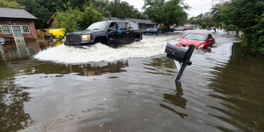 Ein Auto fährt durch das von Hurrikan «Ian» verursachte Hochwasser.