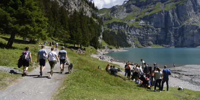 Wanderer bei schönem Wetter am Oeschinensee, oberhalb von Kandersteg BE. Wetter