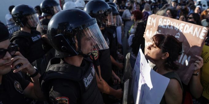 Eine Frau mit einem Plakat trotzt der Polizei, die sie blockiert. Sie nimmt an einer Kundgebung zum ersten Jahrestag des Todes der Iranerin Mahsa Amini in Istanbul teil, 16. September 2023. jahrestag tod mahsa amini
