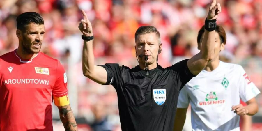 Im Fokus: Schiedsrichter Tobias Welz (M) entscheidet nach Videobeweis auf Elfmeter für Werder Bremen. Foto: Tom Weller