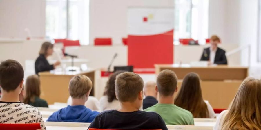 Jugendliche sitzen bei einer Veranstaltung im Plenarsaal des brandenburgischen Landtags. Mehr als zwei Drittel der Erwachsenen trauen der jungen Generation zu, Verantwortung für den Erhalt der Demokratie in Deutschland zu übernehmen. Foto: Christoph Soeder/Symbol