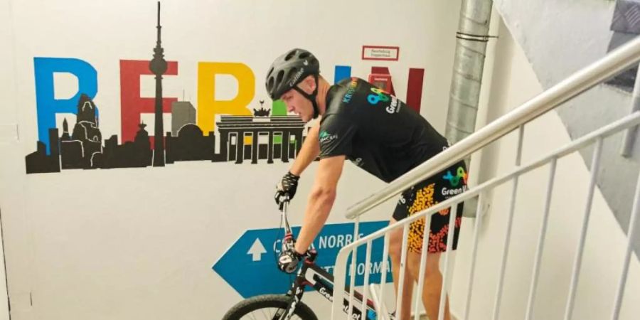 Krystian Herba springt mit seinem Rad im Treppenhaus des Park Inn Hotels die letzten Stufen hinauf. Foto: Annette Riedl