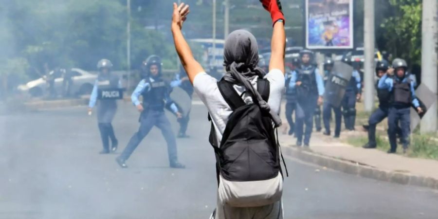 Demonstrant und Polizisten in Tegucigalpa