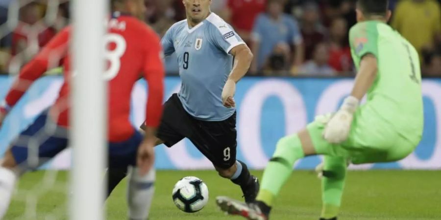 Uruguay-Star Luis Suarez (M) stürmt auf Chile-Keeper Gabriel Arias zu. Foto: Silvia Izquierdo/AP