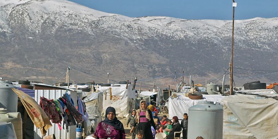 ARCHIV - Syrische Flüchtlinge gehen durch ein Flüchtlingslager in der Bekaa-Ebene. Im Libanon leben rund 1,5 Millionen Syrer. (Archivbild) Foto: Marwan Naamani/dpa