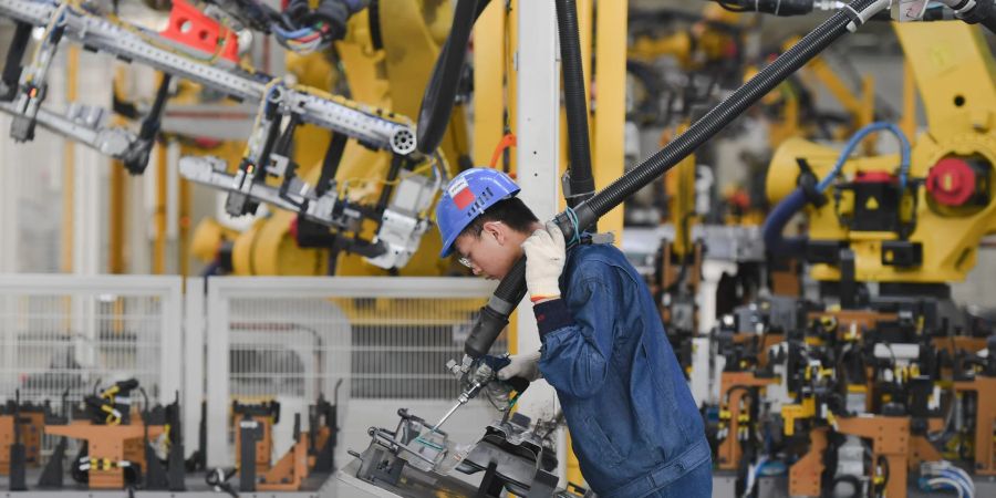 Ein Arbeiter bedient einen Roboter im PKW-Werk am Standort Ningde der SAIC Motor Corporation Ltd. in Ningde in der südostchinesischen Provinz Fujian.