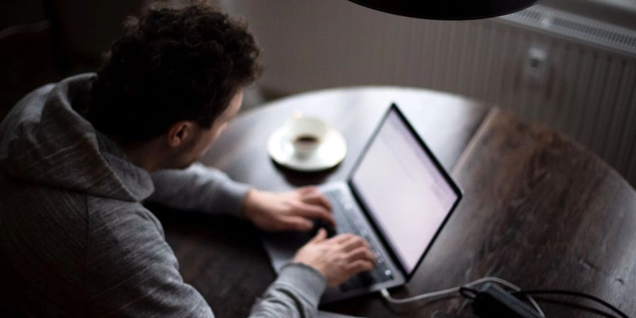 Ein Mann arbeitet an seinem Laptop: Jeder zehnte Erwerbstätige in Deutschland ist nach einer aktuellen Studie arbeitssüchtig.