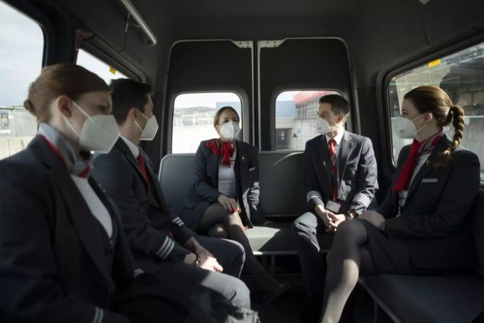 Eine Crew der Schweizer Fluggesellschaft Helvetic Airways wird am Flughafen Zürich mit einem Shuttle-Bus zum Flugzeug gefahren. Auch hier schützen sie sich mit Atemschutzmasken vor dem Coron Coronavirus