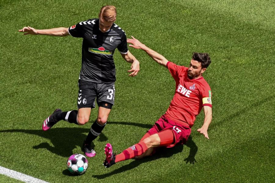 Jonas Hector (r.) vom 1. FC Köln grätscht im Spiel gegen den SC Freiburg.