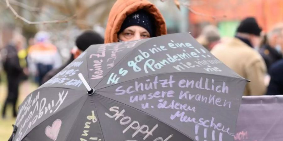 Eine Teilnehmerin der Proteste in Dresden hat ihre Forderungen auf einen Regenschirm geshrieben. Foto: Sebastian Kahnert/dpa-Zentralbild/dpa