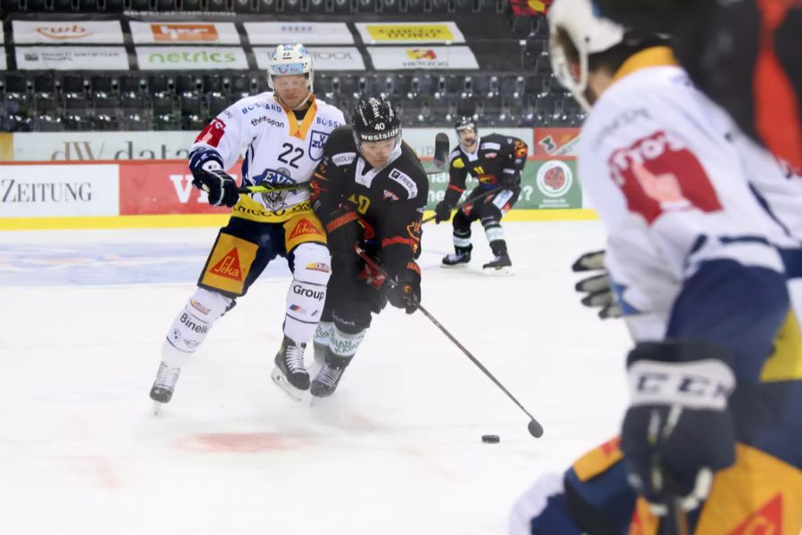 Zugs Santeri Alatalo, links, und Berns Jan Neuenschwander, rechts, kämpfen um den Puck, im sechsten Eishockey Playoff Viertelfinalspiel der National League zwischen dem SC Bern und dem EV Zug, , am Freitag, 23. April 2021, in der Postfinance Arena in Bern.