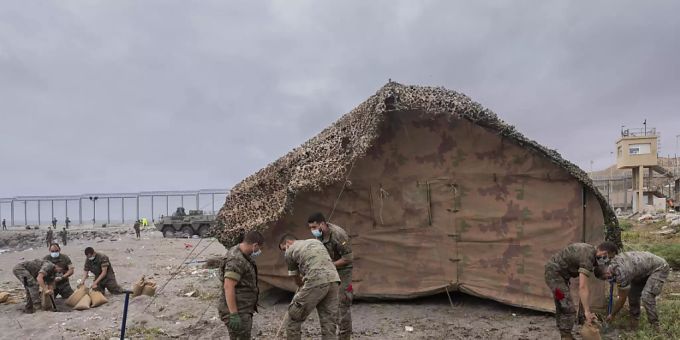 Soldaten der spanischen Armee errichten ein Zelt in der spanischen Enklave Ceuta, direkt an der Grenze zwischen Marokko und Spanien. Foto: Bernat Armangue/AP/dpa Soldaten der spanischen Armee errichten ein Zelt in der spanischen Enklave Ceuta, direkt an der Grenze zwischen Marokko und Spanien. Foto: Bernat Armangue/AP/dpa