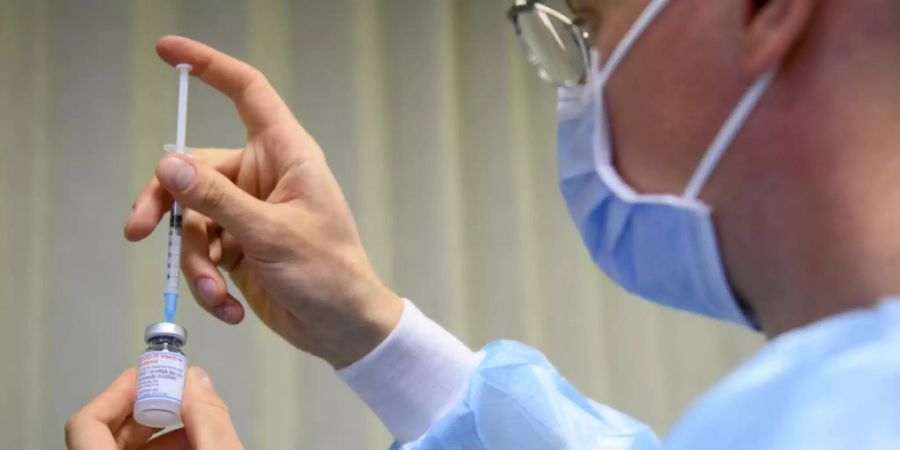 Eine Zuständiger des Gesundheitspersonal zieht eine Spritze mit einem Impfstoff gegen das Coronavirus auf. In der Schweiz wurden bisher 1'077'581 Personen vollständig geimpft. (Archivbild)