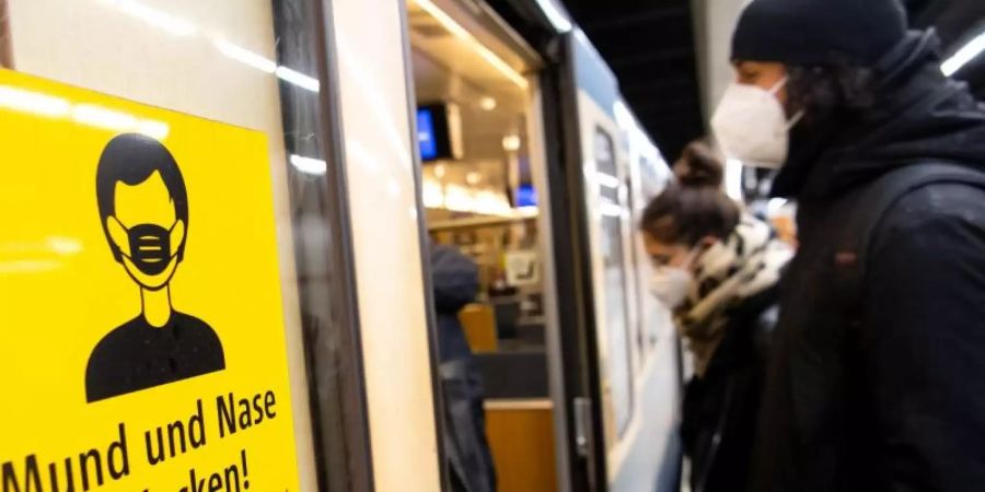 Ein Mann und eine Frau mit FFP2-Masken steigen in eine U-Bahn. Die Wissenschaftler schliessen aus ihrer Studie, dass das Infektionsrisiko im Alltag mit der Nutzung des ÖPNV nicht steigt. Foto: Sven Hoppe/dpa