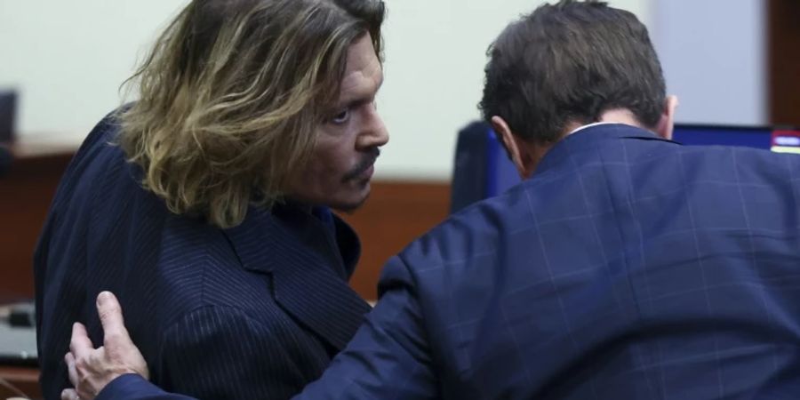 US-Star Depp (l)  berät sich vor Gericht mit seinem Anwalt