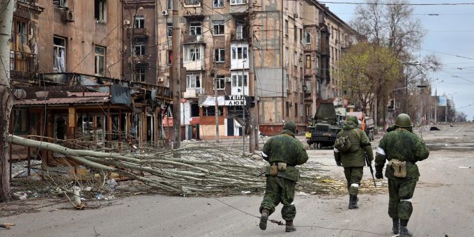 Soldaten der Miliz der «Volksrepublik» Donezk gehen an beschädigten Wohnhäusern in Mariupol vorbei. Alexei Alexandrov/AP/dpa Soldaten in Mariupol