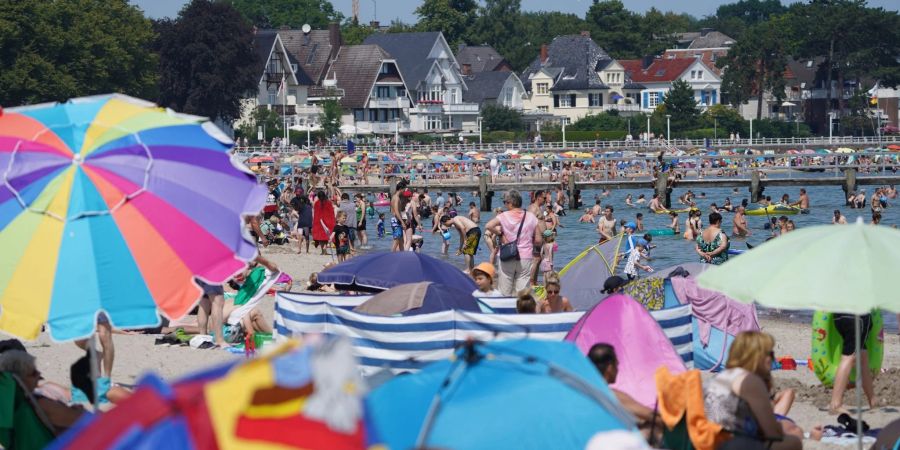 Urlauber und Tagestouristen geniessen das Sommerwetter am Ostseestrand in Travemünde.