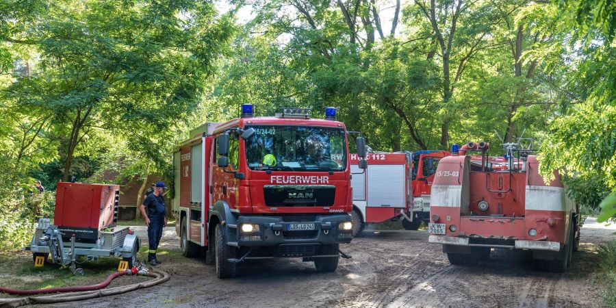 Ein Fahrzeug der Feuerwehr fährt in der Nähe des Einsatzortes durch den Wald.