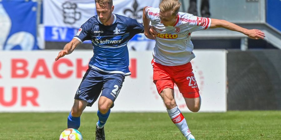 Jahn-Torschütze Joshua Mees (r) setzte sich mit Regensburg gegen Matthias Bader und Darmstadt 98 durch.