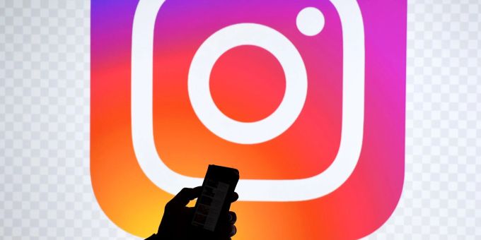 Ein Smartphone vor dem Logo von Instagram. Ein Smartphone vor dem Logo von Instagram.