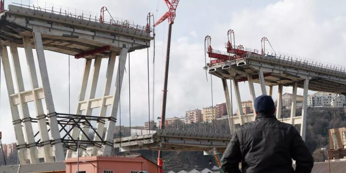 Ein Mann beobachtet das Absenken eines Abschnitts der Morandi-Brücke. (Archivbild) genua brücke