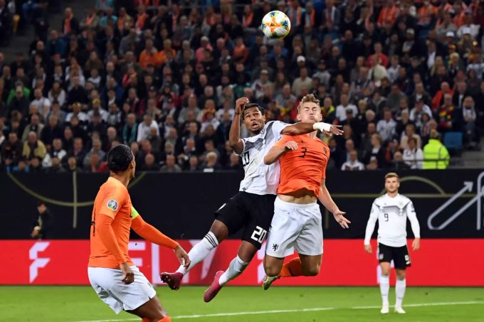 Serge Gnabry aus Deutschland (M, l.) und Matthijs de Ligt aus den Niederlanden im Kopfballduell. Deutschland - Niederlande DFB