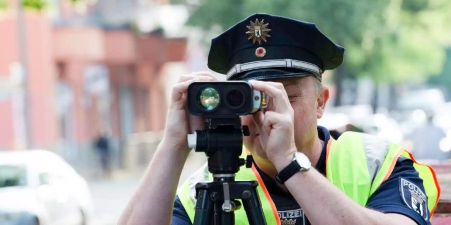 Polizist bei einer Geschwindigkeitsmessung