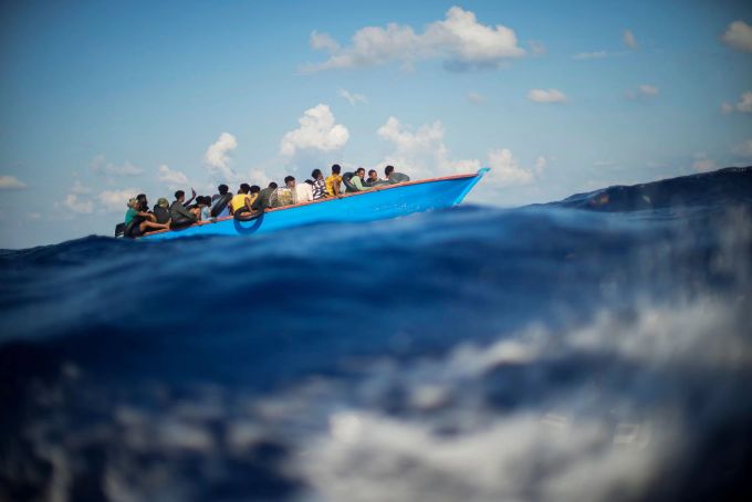 Migranten sitzen südlich der italienischen Insel Lampedusa auf dem Mittelmeer in einem Holzboot. (Archivbild) Migranten im Mittelmeer