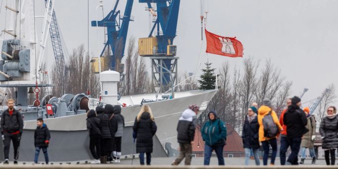 Passanten spazieren bei wechselhaftem Wetter am Hafen in Hamburg. Passanten spazieren bei wechselhaftem Wetter am Hafen in Hamburg.