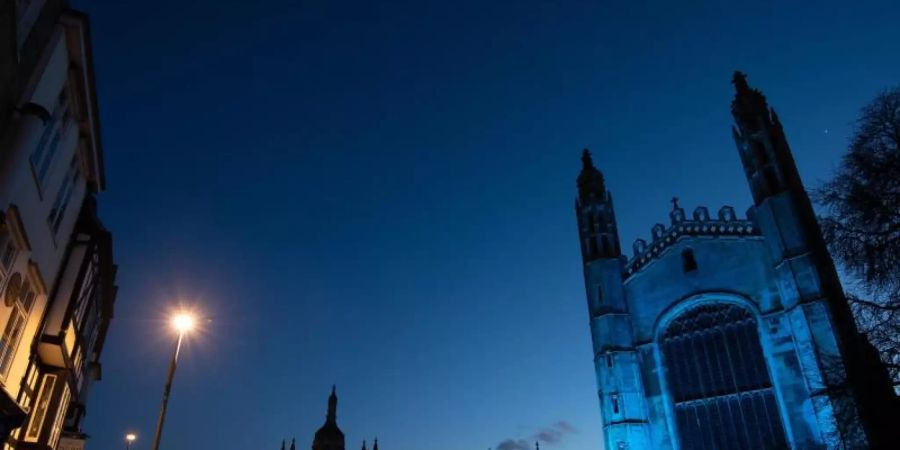 Das Kings College an der Uni Cambridge ist blau beleuchtet. Foto: Joe Giddens/PA Wire/dpa