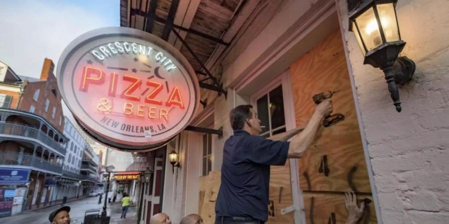 Die Scheiben eines Restaurants in New Orleans werden mit Holzpanelen vor der Ankunft des Hurrikans «Ida» geschützt. Foto: Matthew Hinton/AP/dpa