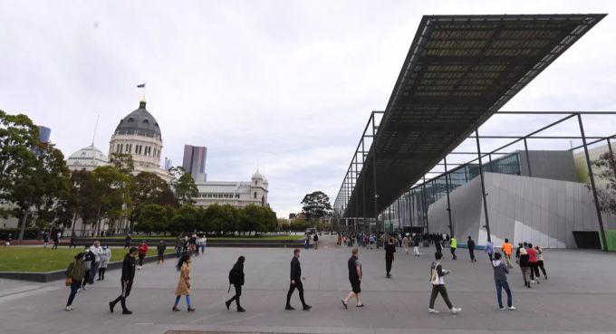 Leute stehen vor einem Impfzentrum in Melbourne Schlange. Impfen