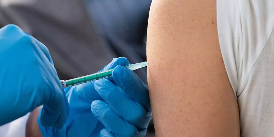 Eine Frau wird während einer Impfaktion auf dem Wochenmarkt in Giessen mit dem Impfstoff von Biontech/Pfizer gegen das Coronavirus geimpft. Foto: Sebastian Gollnow/dpa