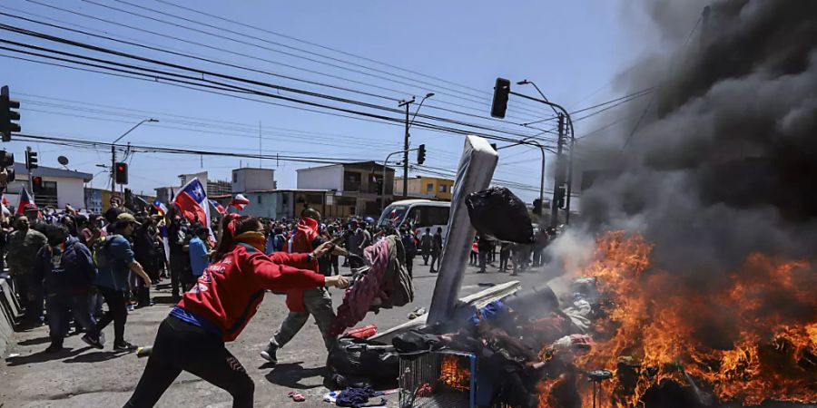 Menschen verbrennen Zelte und Gegenstände venezolanischer und kolumbianischer Migranten während einer Demonstration gegen illegale Einwanderung. Foto: Ignacio Muñoz/AP/dpa