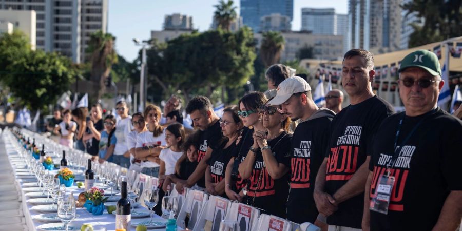 Angehörige von Menschen, die von Hamas-Kämpfern entführt wurden, beten in Tel Aviv umgeben von 203 leeren Stühlen.