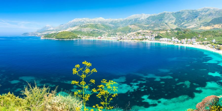 Blick auf eine malerische Bucht in Albanien mit Bergkulisse im Hintergrund.