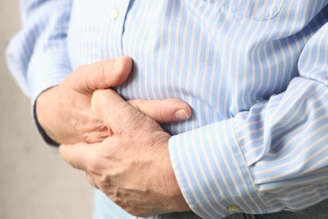 mann hält seinen blähbauch