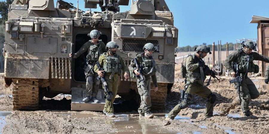 Israelische Soldaten steigen aus einem gepanzerten Fahrzeug nahe der Grenze zwischen Israel und Gaza im Süden Israels.