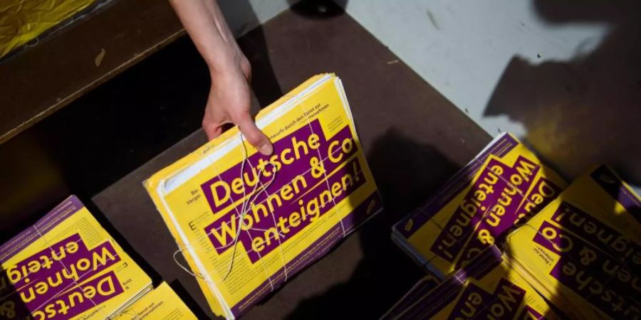 Eine freiwillige Helferin der Initiative «Deutsche Wohnen &amp; Co enteignen» mit einem Stapel von Unterschriften. Foto: Gregor Fischer/dpa