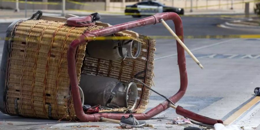 Der Korb eines abgestürzten Heissluftballons liegt auf dem Bürgersteig einer belebte Strasse in Albuquerque. Insgesamt starben fünf Insassen. Foto: Andres Leighton/AP/dpa
