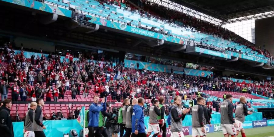 Die Mannschaft von Dänemark kehrt nach einer Spielunterbrechung ins Stadion zurück. Foto: Friedemann Vogel/POOL EPA/AP/dpa