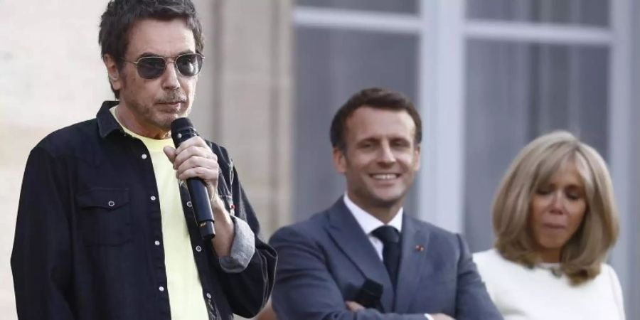 Jean-Michel Jarre (l) spricht vor Staatschef Emmanuel Macron und seiner Frau Brigitte. Foto: Ian Langsdon/EPA POOL/AP/dpa